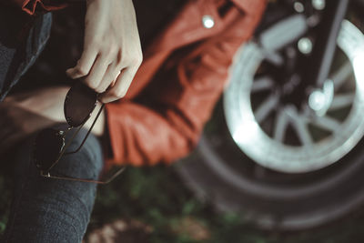 Midsection of woman holding sunglasses outdoors