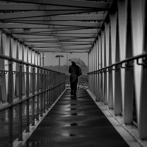 Rear view of man standing on footbridge