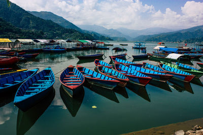 Boats moored in lake against sky