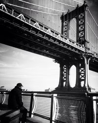 Man walking on bridge over river