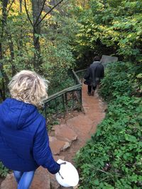 Rear view of woman standing against plants