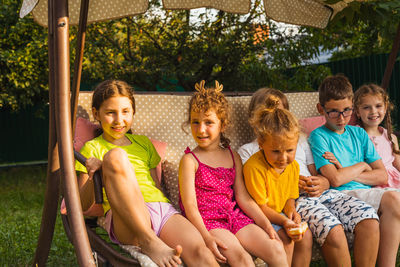 Portrait of happy friends sitting outdoors