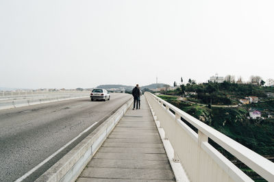 People walking on road against clear sky