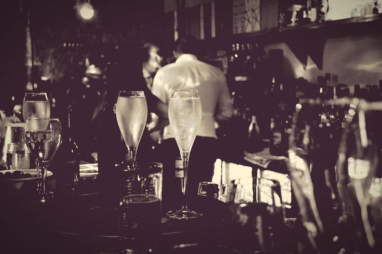 REAR VIEW OF MAN STANDING IN FRONT OF GLASS OF RESTAURANT