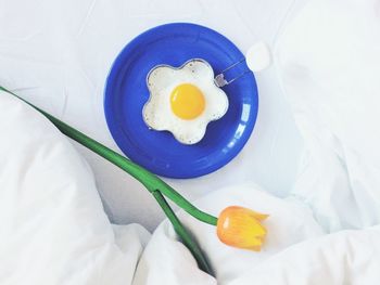 High angle view of artificial flower with fried egg on sheet