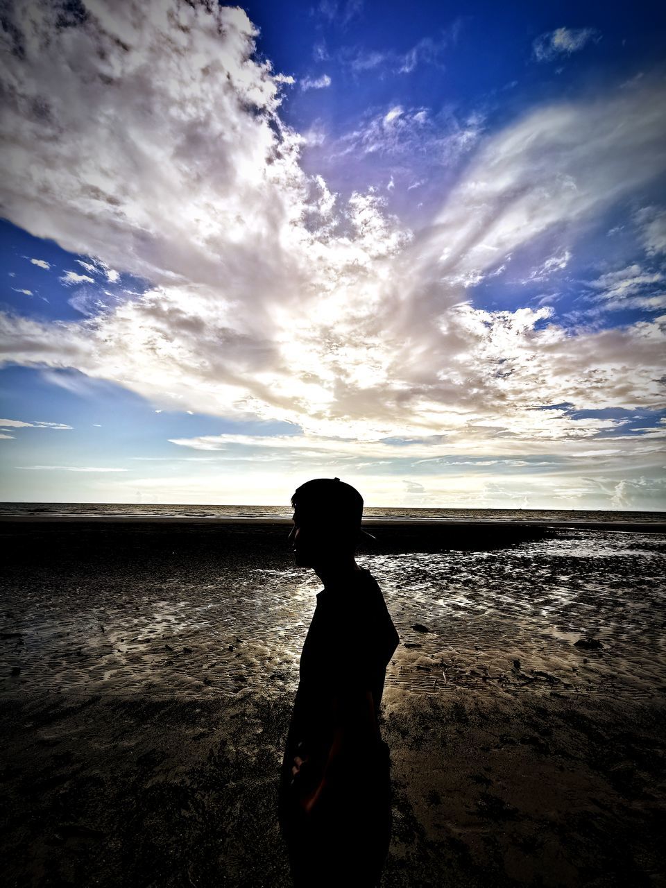 sky, horizon, cloud, water, sea, beach, sunlight, land, sunset, ocean, nature, one person, reflection, dusk, child, beauty in nature, light, scenics - nature, wave, silhouette, horizon over water, childhood, evening, coast, sun, holiday, vacation, men, trip, standing, tranquility, sand, shore, leisure activity, rear view, outdoors, darkness, tranquil scene, blue, emotion, person, environment, solitude, three quarter length, adult, lifestyles