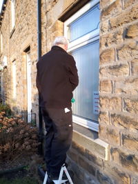 Rear view of man walking by building