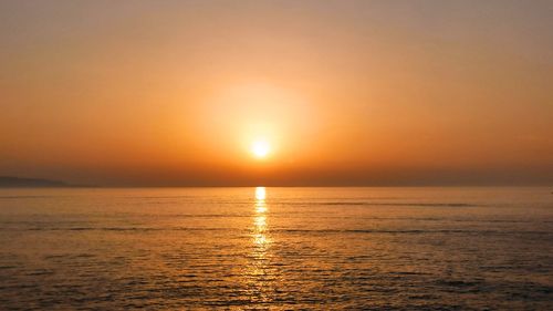 Scenic view of sea against orange sky