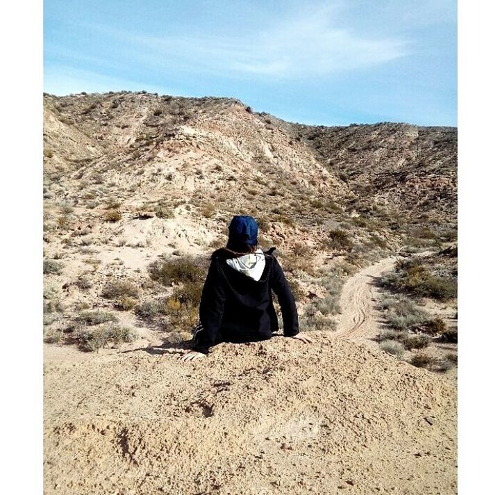 rear view, real people, nature, sky, lifestyles, day, one person, leisure activity, landscape, mountain, environment, sunlight, rock, sitting, auto post production filter, transfer print, non-urban scene, tranquility, adult, outdoors