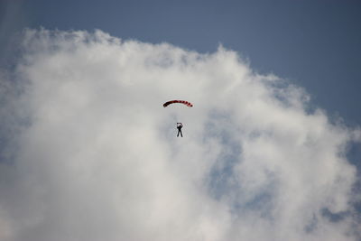 Low angle view of person paragliding against sky