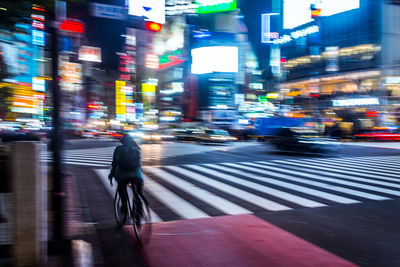 Blurred motion of man cycling on city street