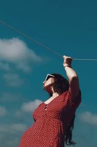 Rear view of woman standing against sky