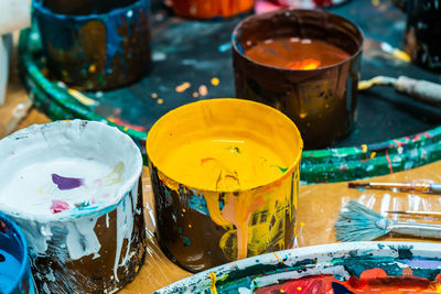 Jars of the artist with bright colors in the art workshop