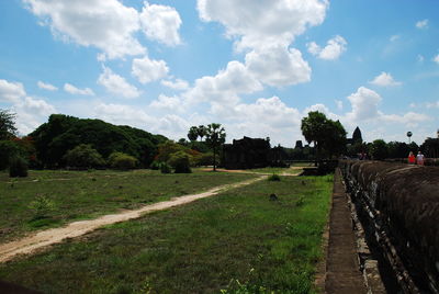 Road amidst field against sky