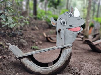 Close-up of toy on wood in field