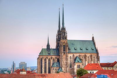 Church in city against sky during sunset