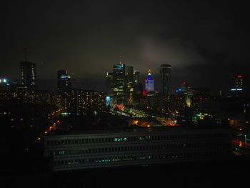 Illuminated cityscape against sky at night