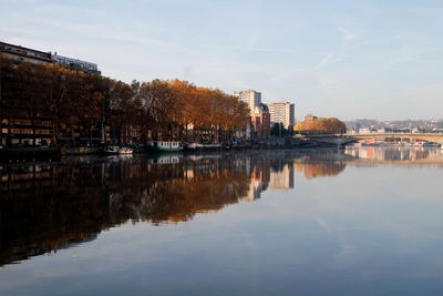 Reflection of buildings in lake against sky