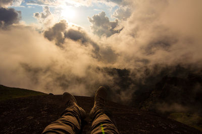 Low section of person in mountains against sky