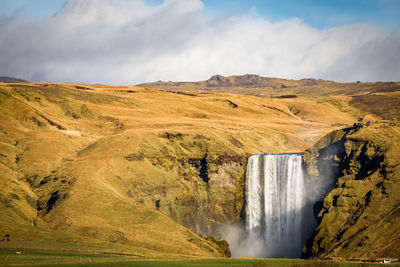 Scenic view of waterfall against sky