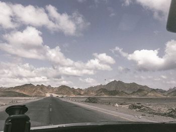 Road leading towards mountains against sky