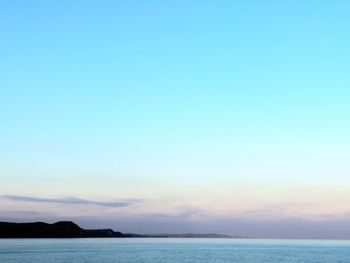 Scenic view of sea against clear sky during sunset