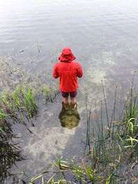 Rear view of man standing in lake