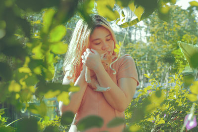 Young woman with kitten in park