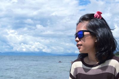 Portrait of woman looking at sea against sky, lakeside view mountains