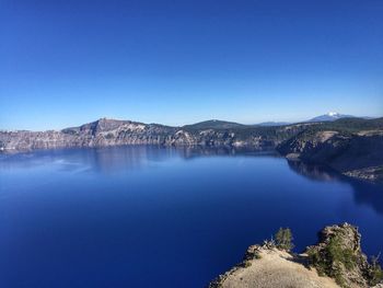 Scenic view of lake against clear blue sky