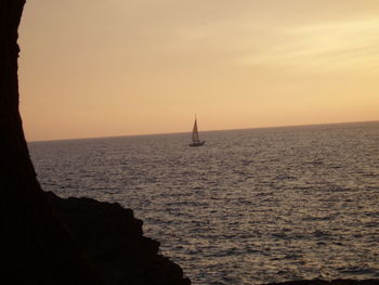 Sailboat sailing on sea against sky during sunset