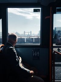 Rear view of man sitting in train in london, uk