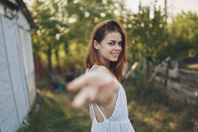 Portrait of smiling young woman standing outdoors