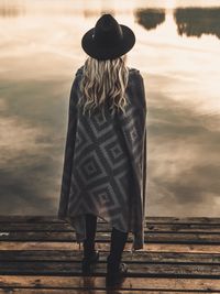 Rear view of woman standing by water