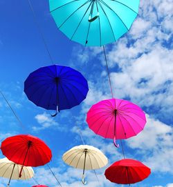 Low angle view of umbrellas hanging against sky