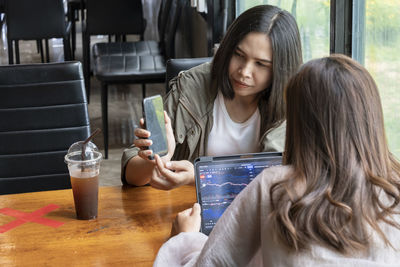 Side view of woman sitting in cafe and meeting.