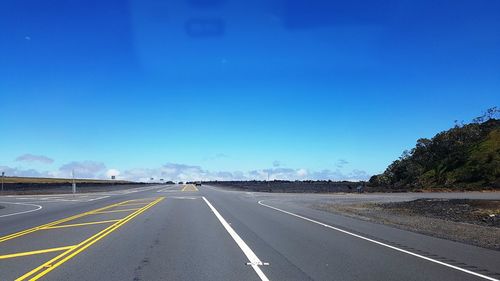 Road against clear blue sky