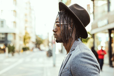 Portrait of man with umbrella on street in city