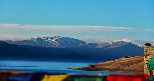 Scenic view of lake and mountains against blue sky