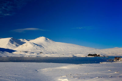 Scenic view of snowcapped mountains against blue sky