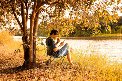 Man sitting by lake on chair