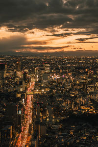 High angle view of illuminated cityscape against sky at night