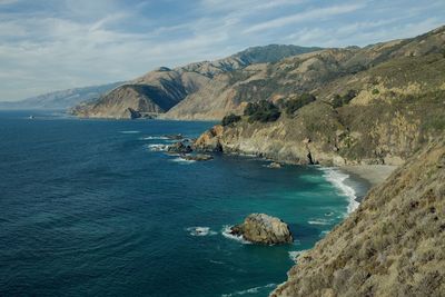 Scenic view of sea and mountains against sky