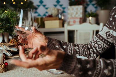 Midsection of woman drinking glass on table