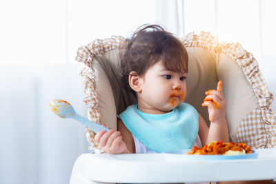 Cute girl eating food at home