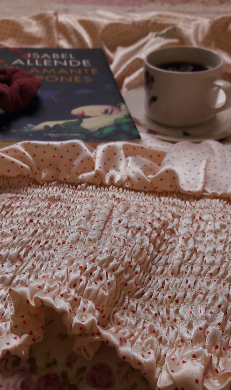 HIGH ANGLE VIEW OF COFFEE CUP ON BED