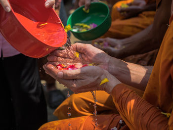 The hand of the thai people poured water in the hands of the monk songkran festival.