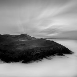 Scenic view of sea and mountains against sky