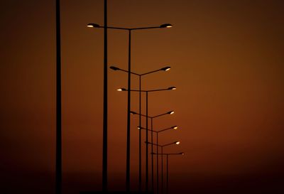 Low angle view of illuminated lights against orange sky