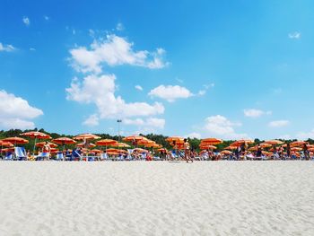 Crowd on beach against blue sky